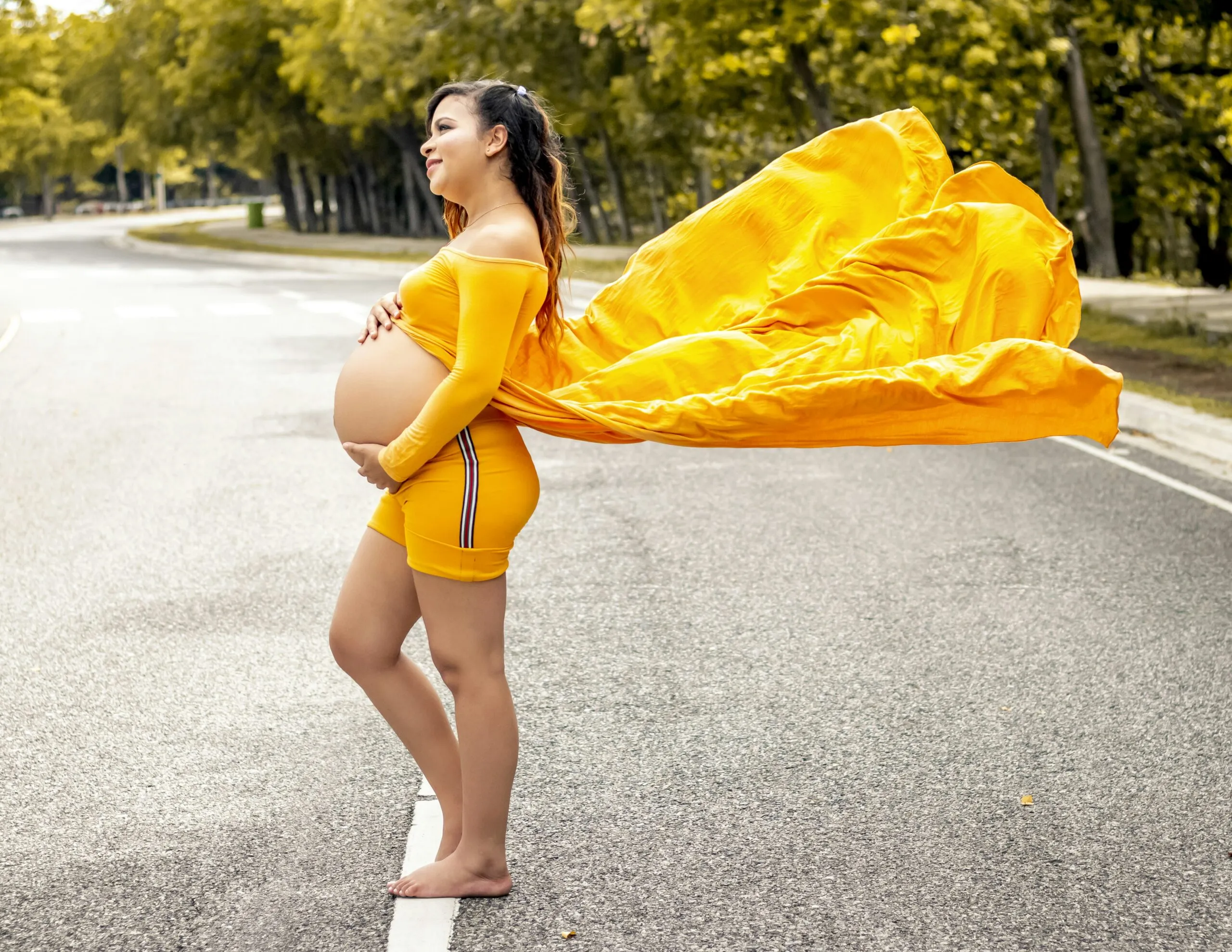woman in yellow sleeveless dress standing on road during daytime
