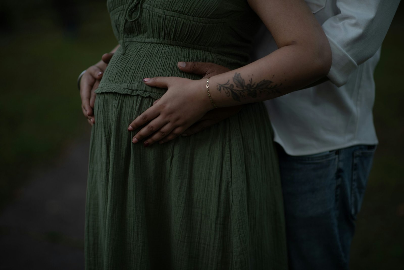 Couple holding pregnant belly outdoors