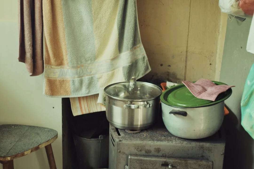 a stove top oven sitting next to a pot on top of a wooden table