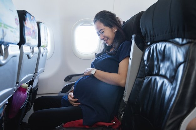 Asian pregnant women enjoy traveling by airplane
