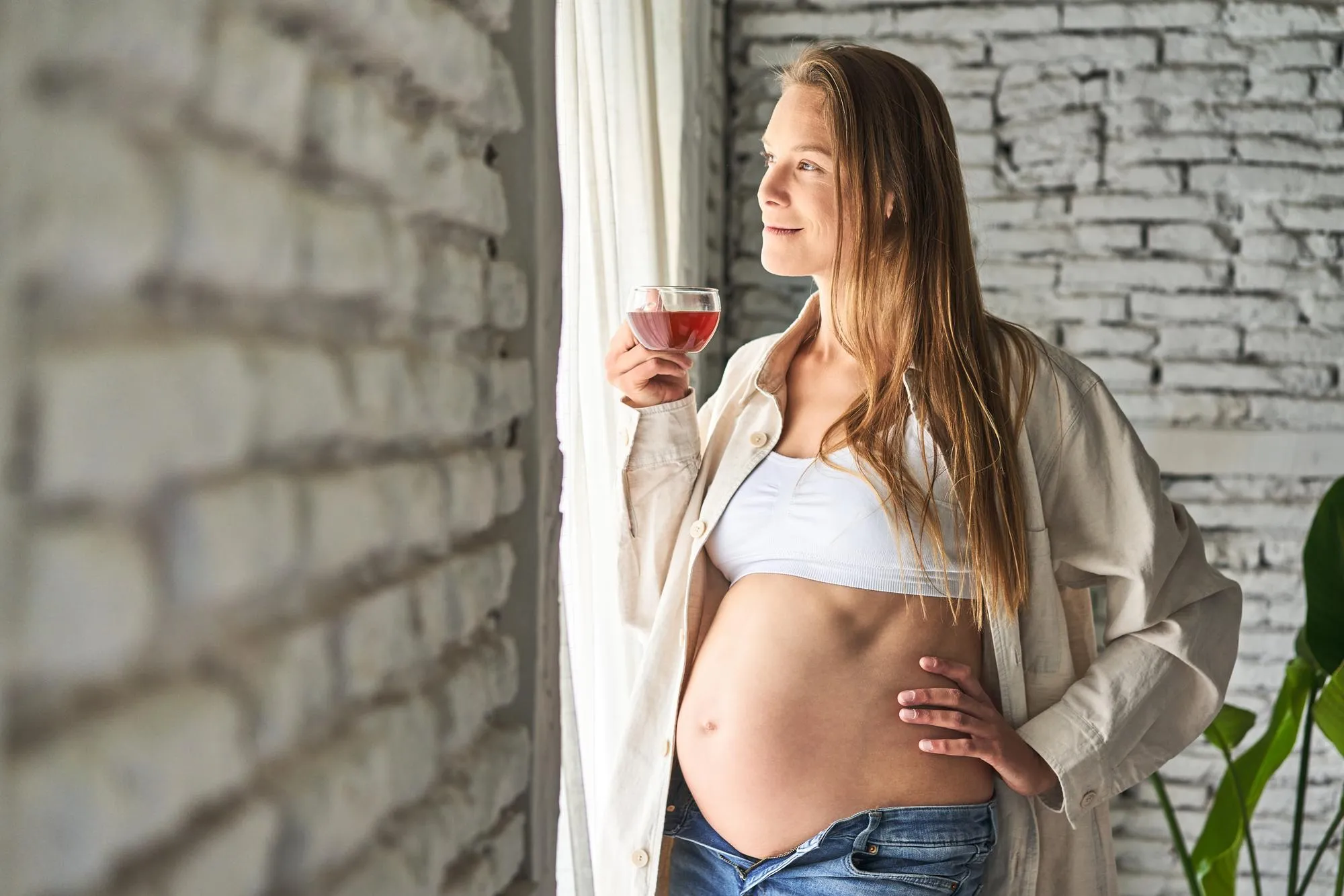 Backlit pregnant woman savoring a relaxing tea serene and content