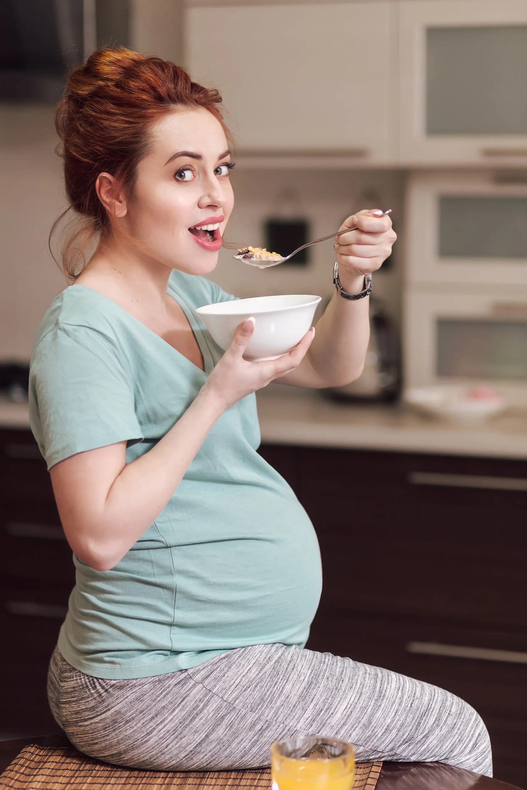Beautiful pregnant woman eating cereals