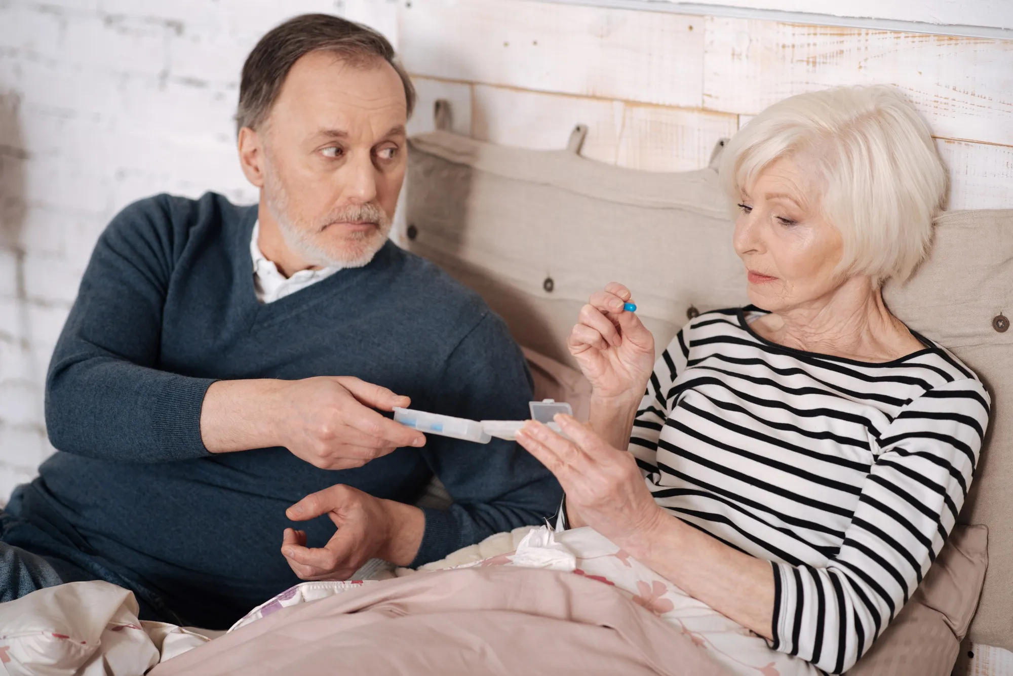 For better. Close up of aged sick lady taking pill from her elderly husband.