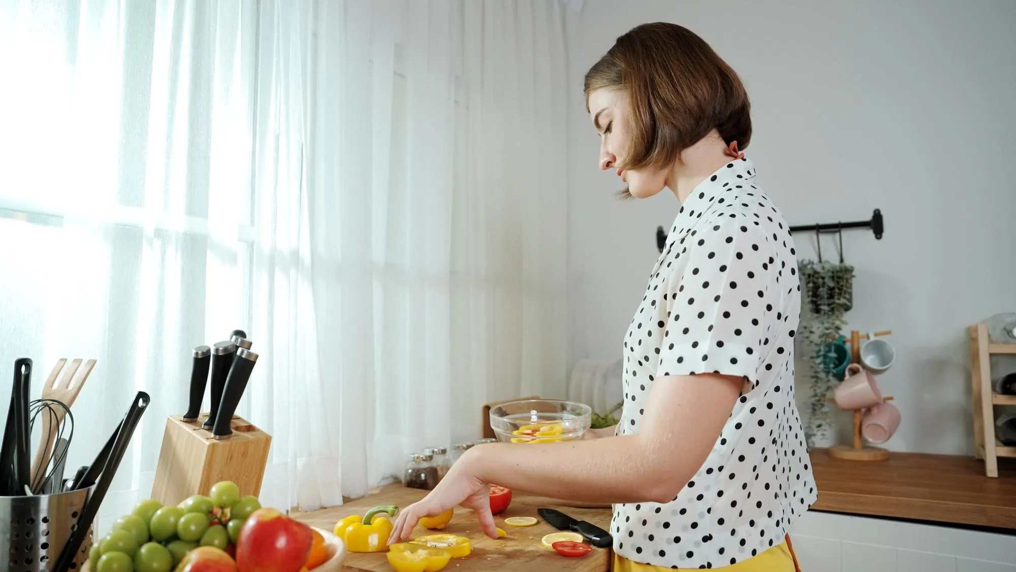 Caucasian mother put vegetable in bowl making a salad for breakfast pedagogy