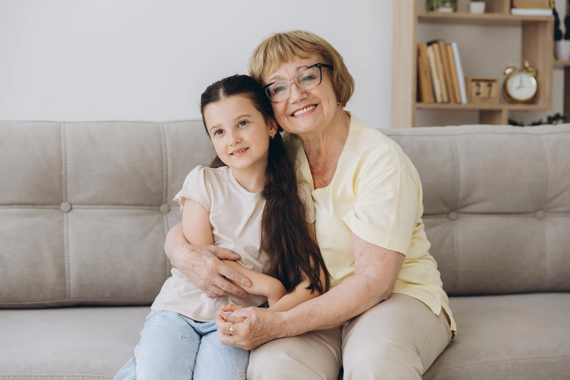 Cheerful cute granddaughter kid and happy grandma hugging with love tenderness affection Grandmother embracing grandchild enjoying family relationship