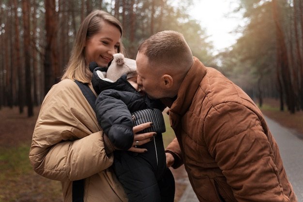 Couple with baby outdoors medium shot