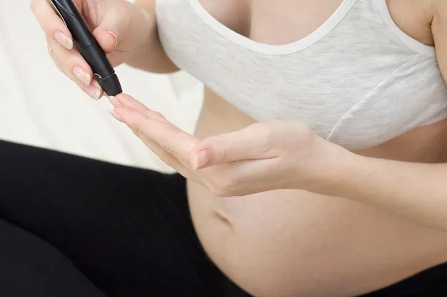 Diabetes of pregnant women. A pregnant woman with a stomach measures the level of glucose in the blood with a glucometer.