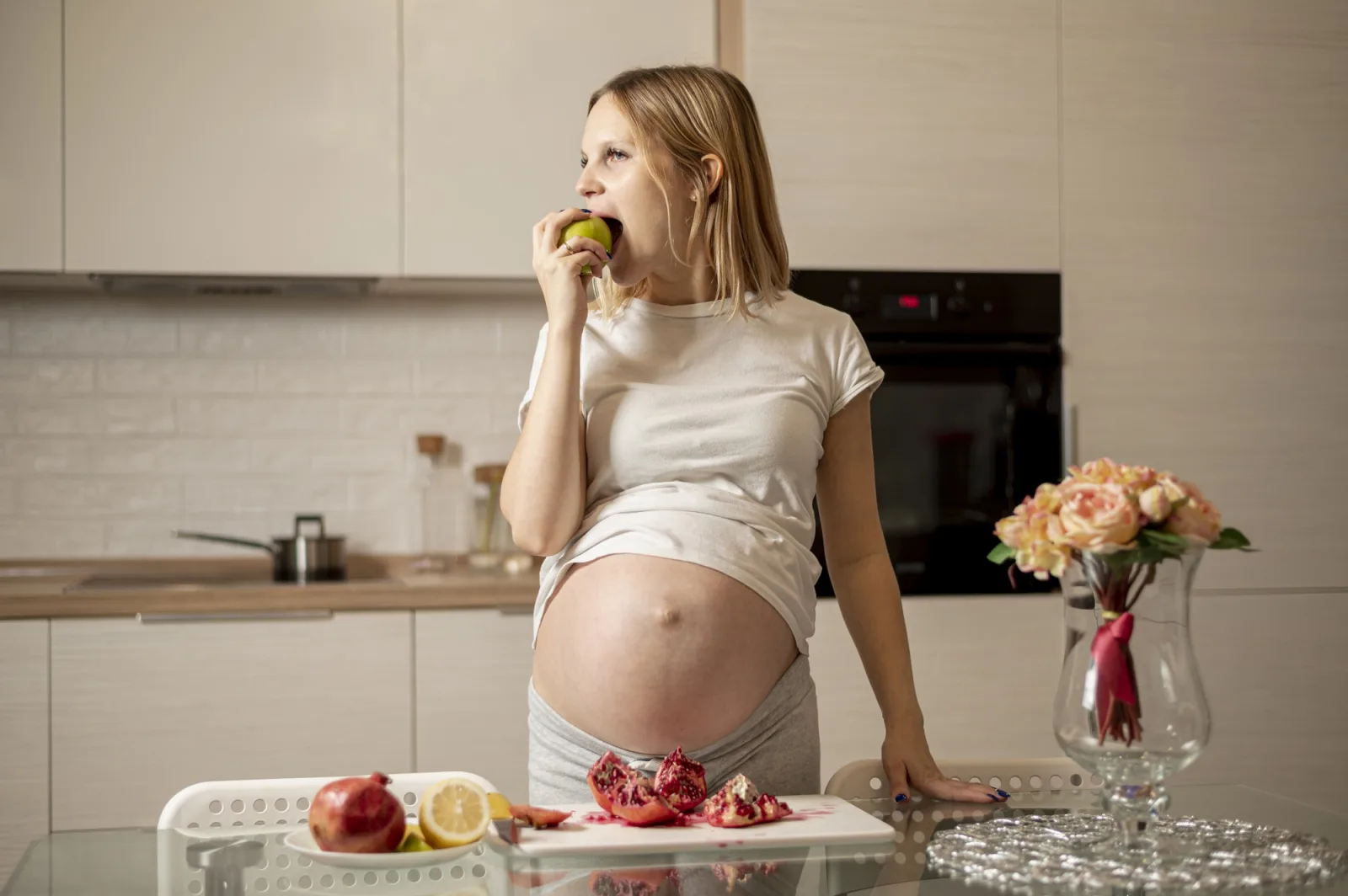 Front view pregnant woman eating an apple