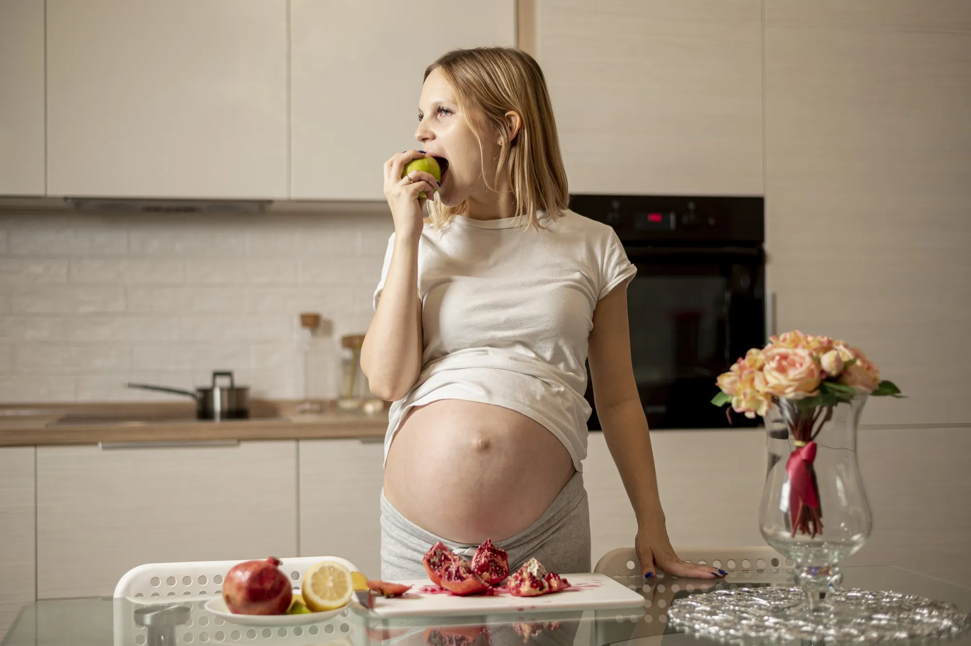 Front view pregnant woman eating an apple