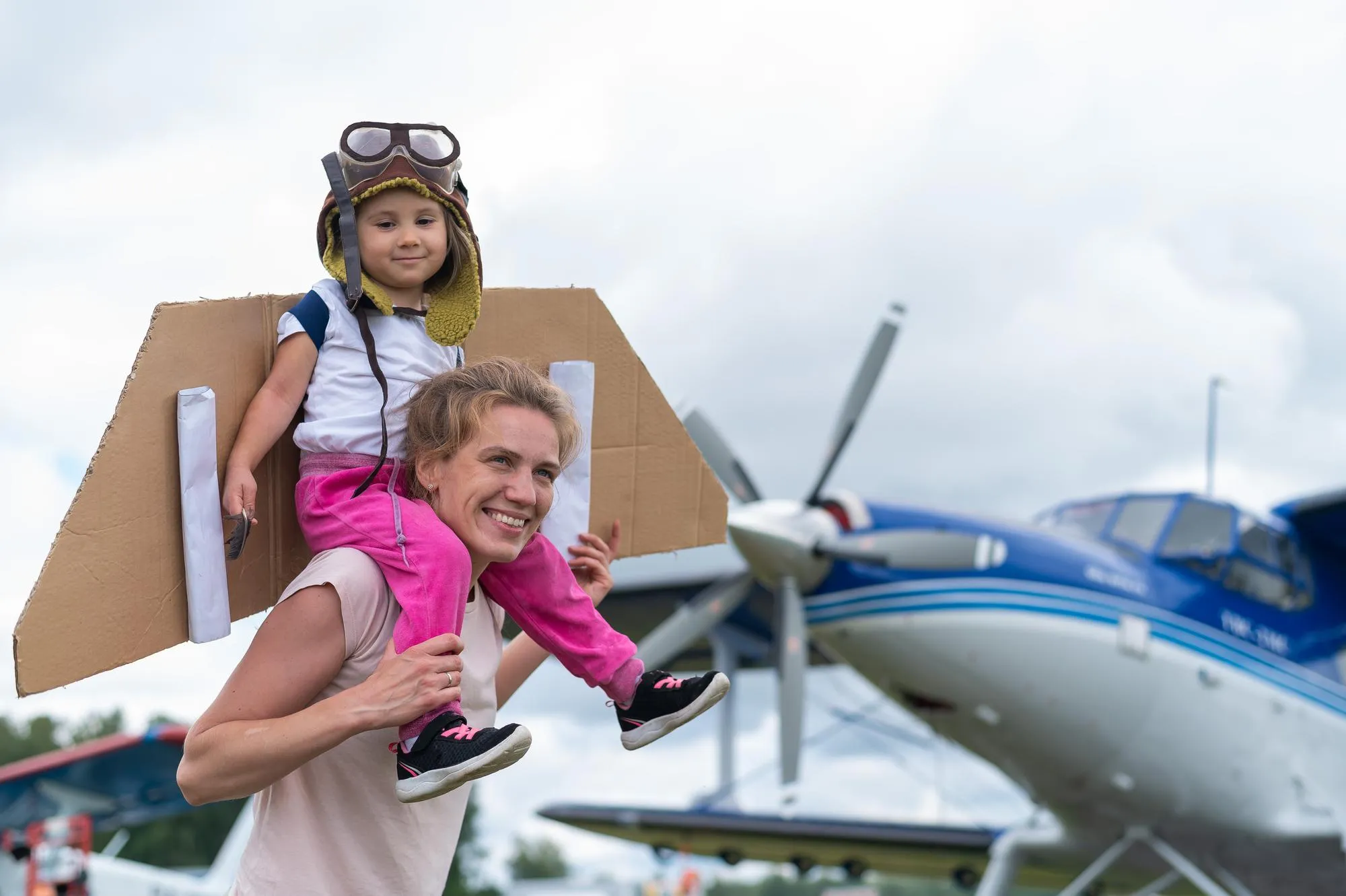 Full length of girl with mother against airplane
