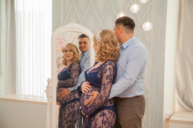Handsome future parents look at the reflection in the mirror