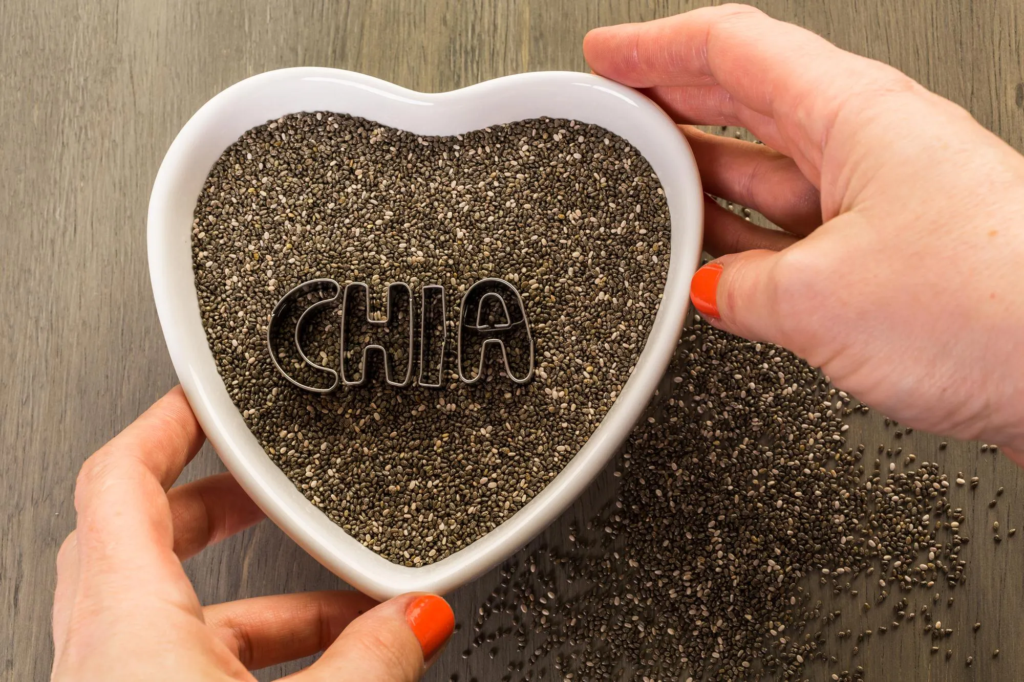 Healthy Chia seeds in a heart shape bowl close-up.