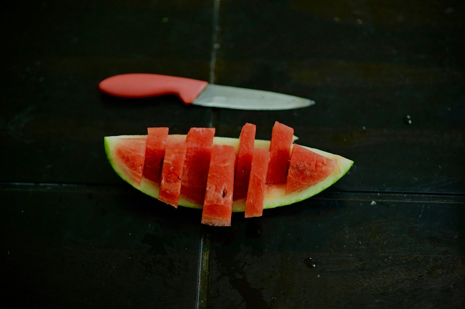 sliced watermelon on black wooden table