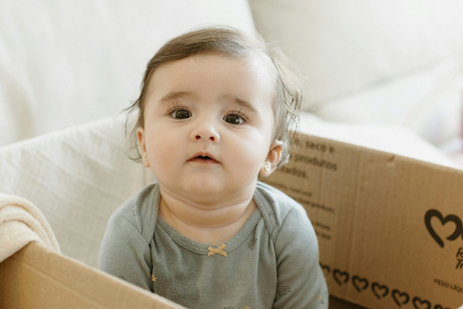 A small child sitting in a cardboard box