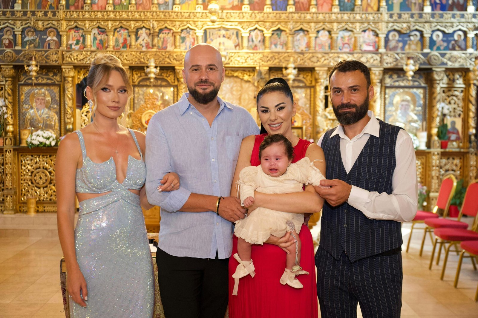 Family posing with a baby in a church.