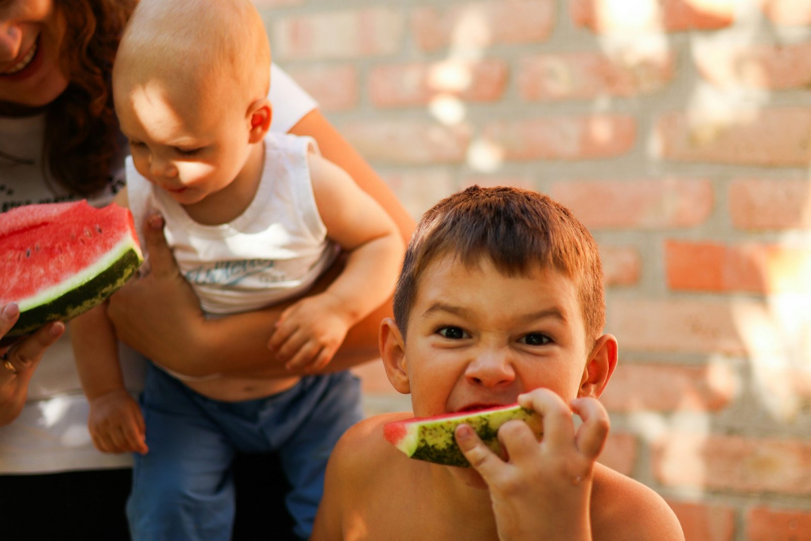 a young boy eating a piece of watermelon