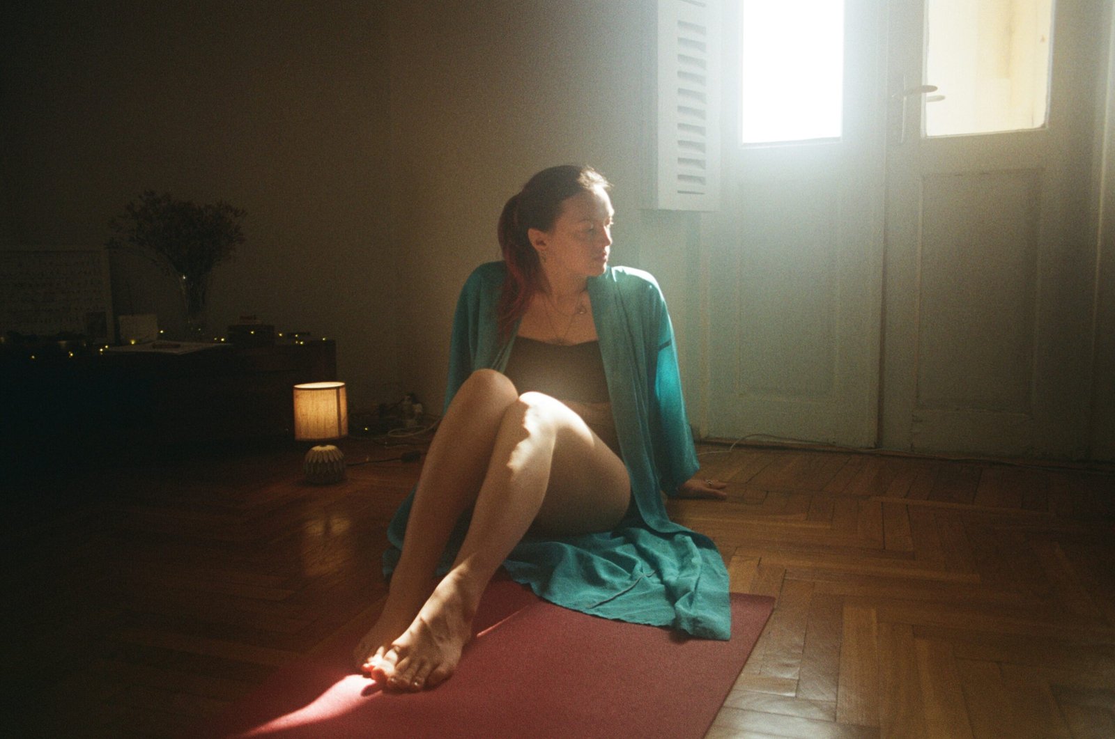 A woman sitting on a yoga mat in a room