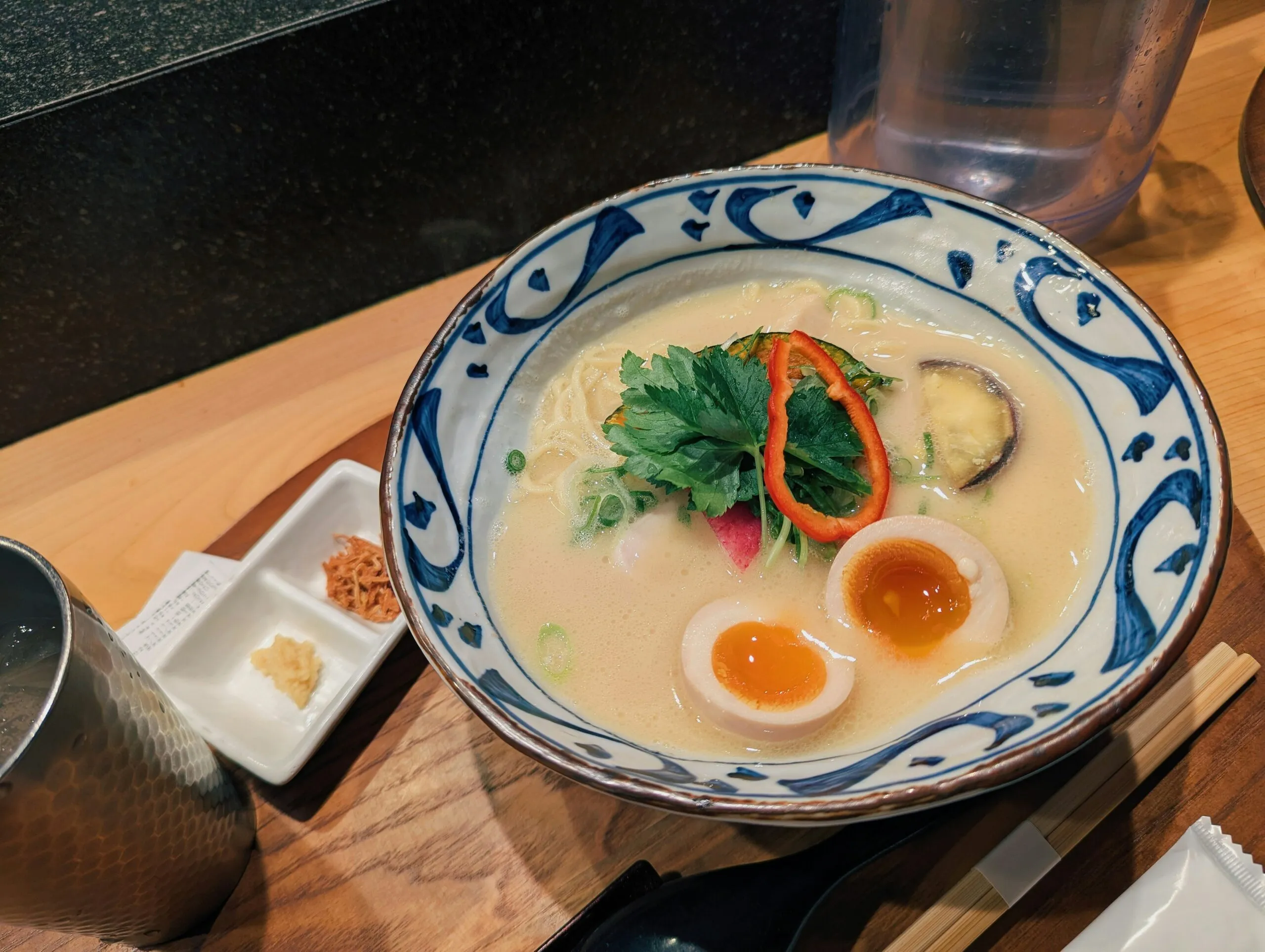 A bowl of creamy ramen with egg and vegetables