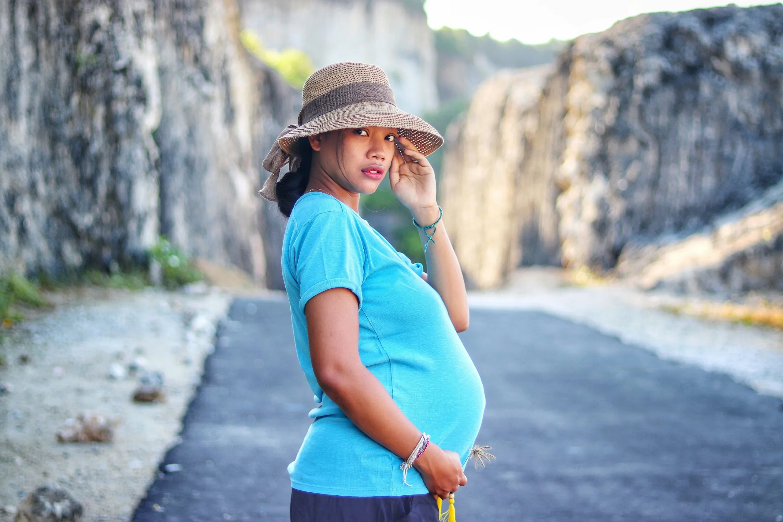 woman in blue top wearing hat