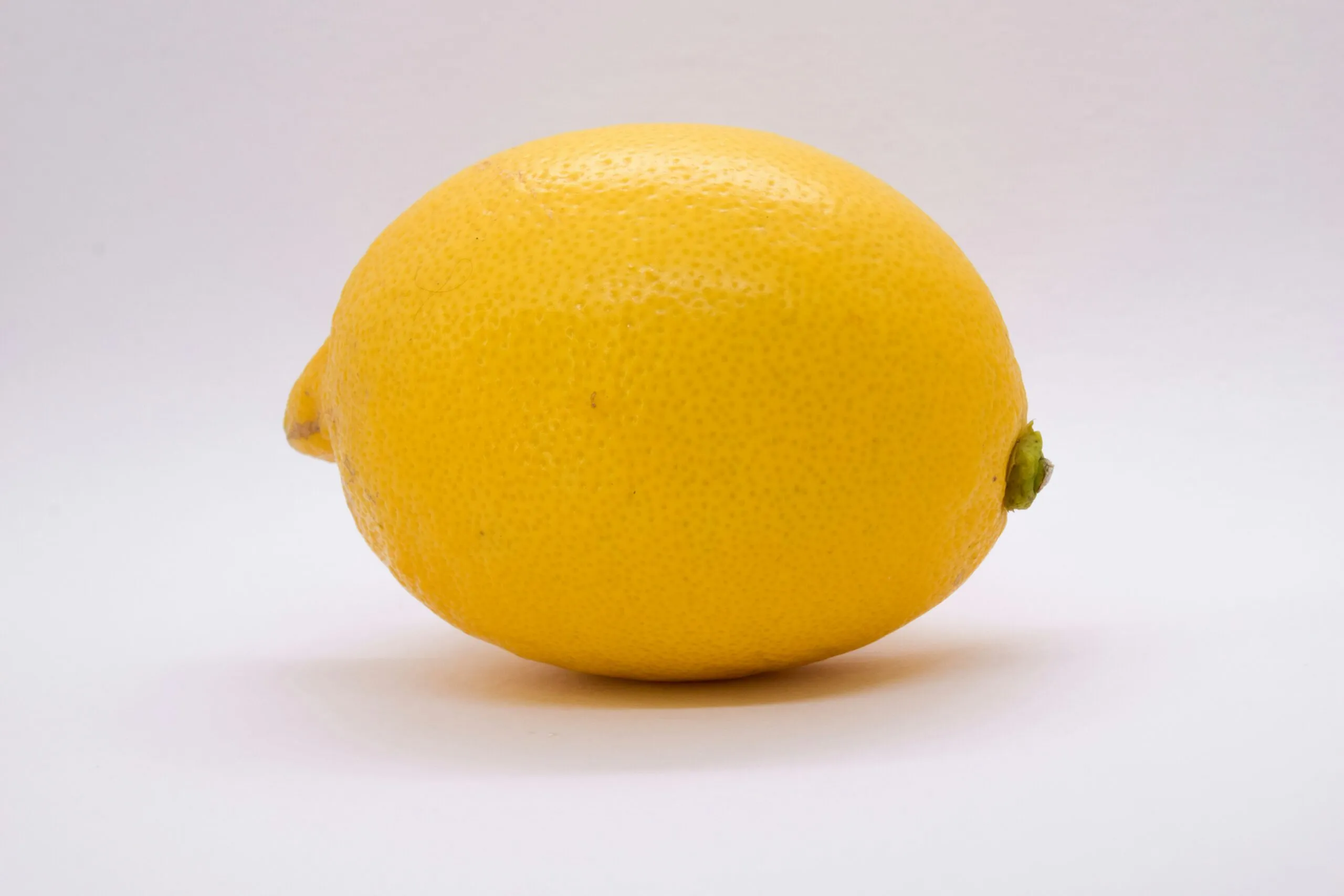 a single lemon sitting on top of a white table