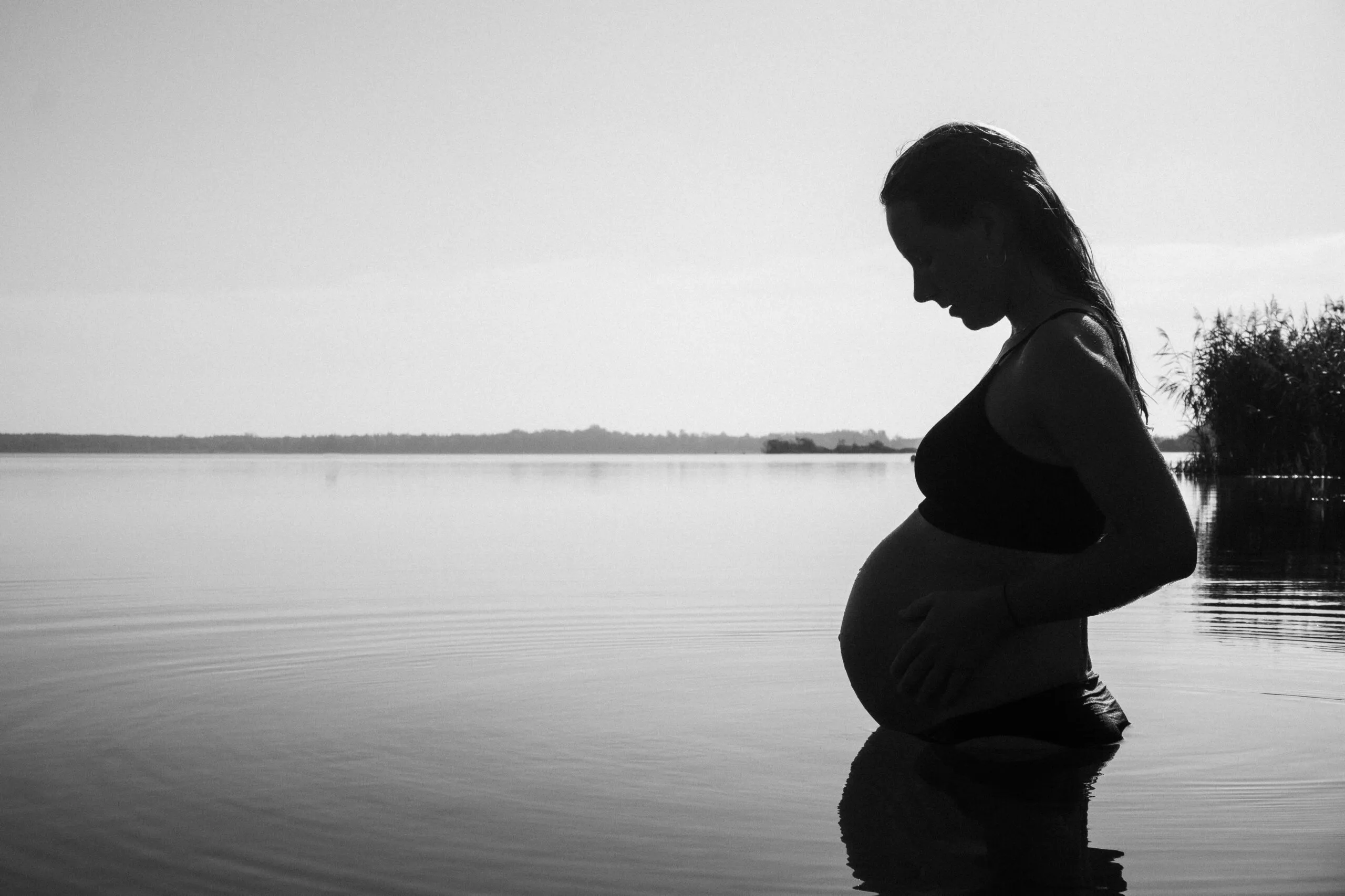 a pregnant woman is standing in the water