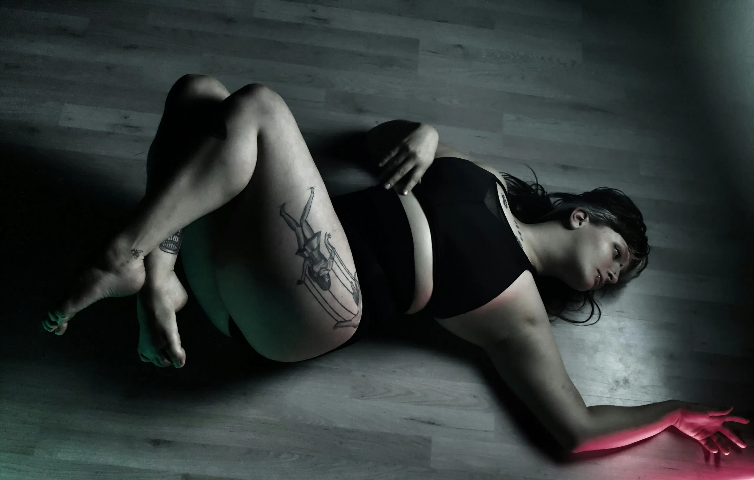 a woman laying on the floor in a black bikini
