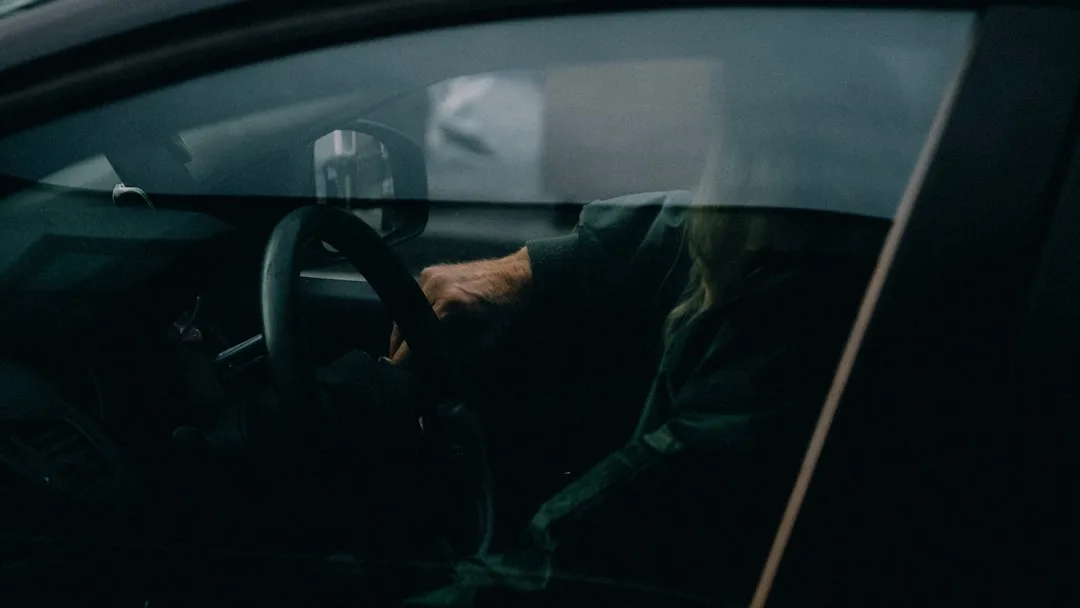 a woman driving a car in the dark