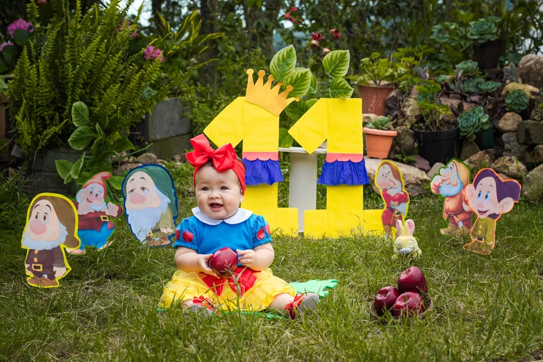 a child sitting in the grass with a group of gnomes
