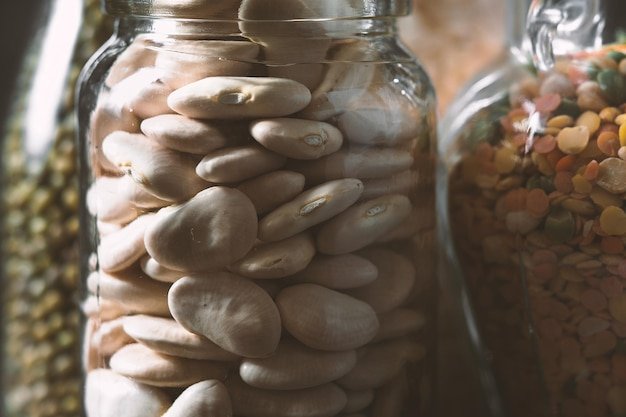 Large white beans in a glass jar is a side view horizontal