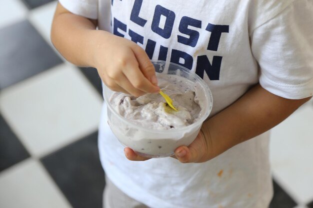 Midsection of man holding ice cream in bowl
