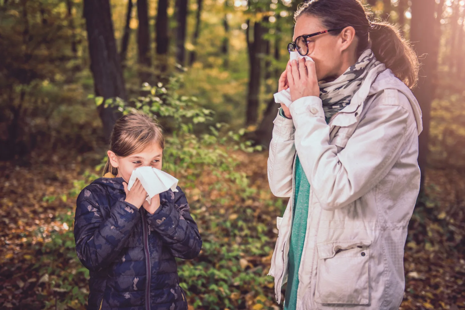 Mother and daughter blowing her nose