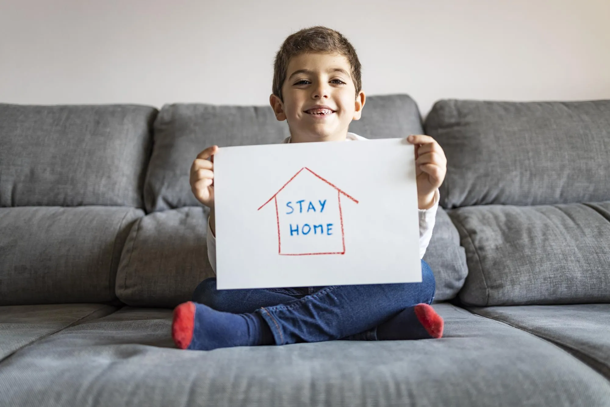 Portrait of boy sitting on sofa at home