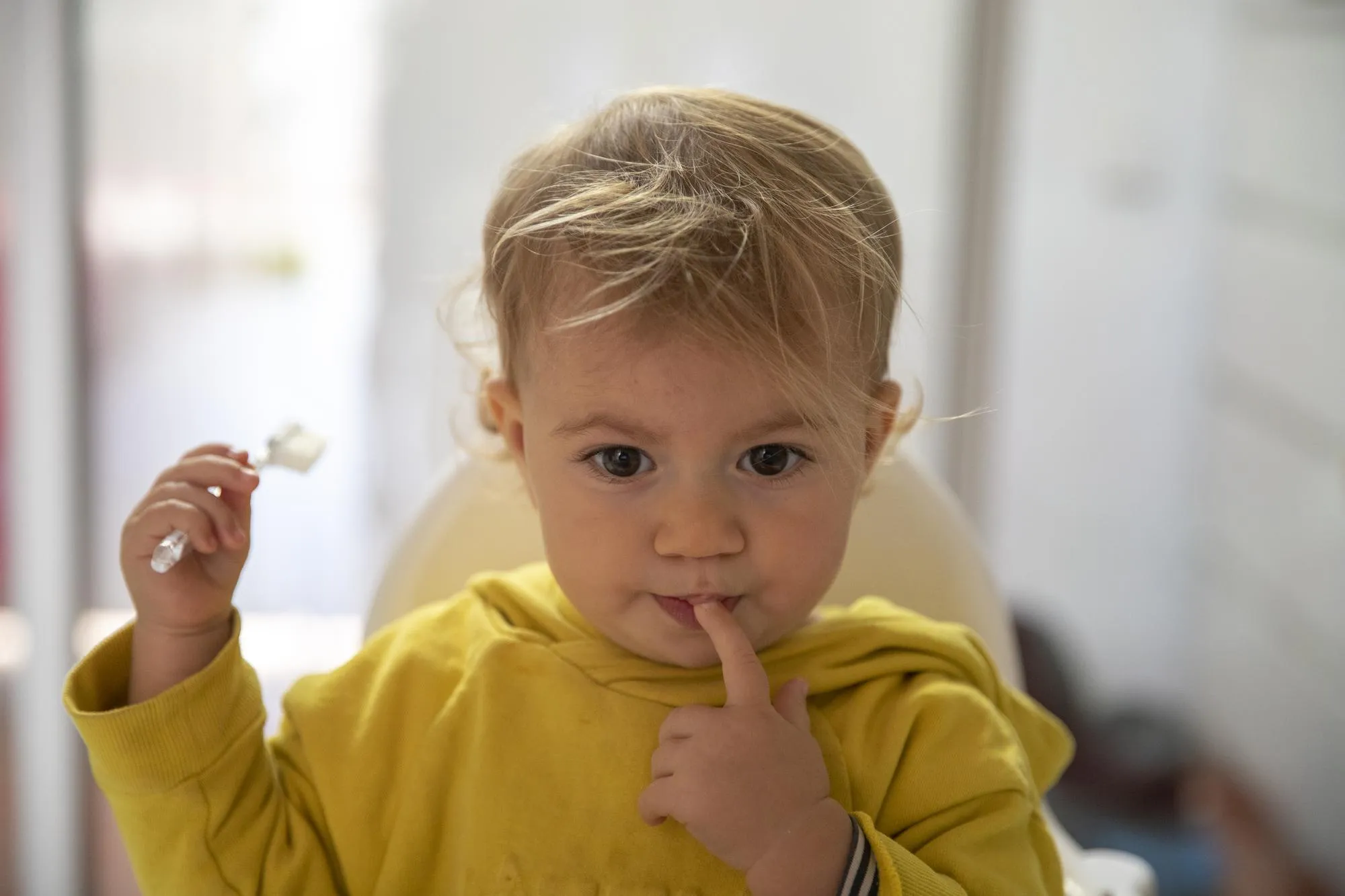 Portrait of cute baby girl licking finger