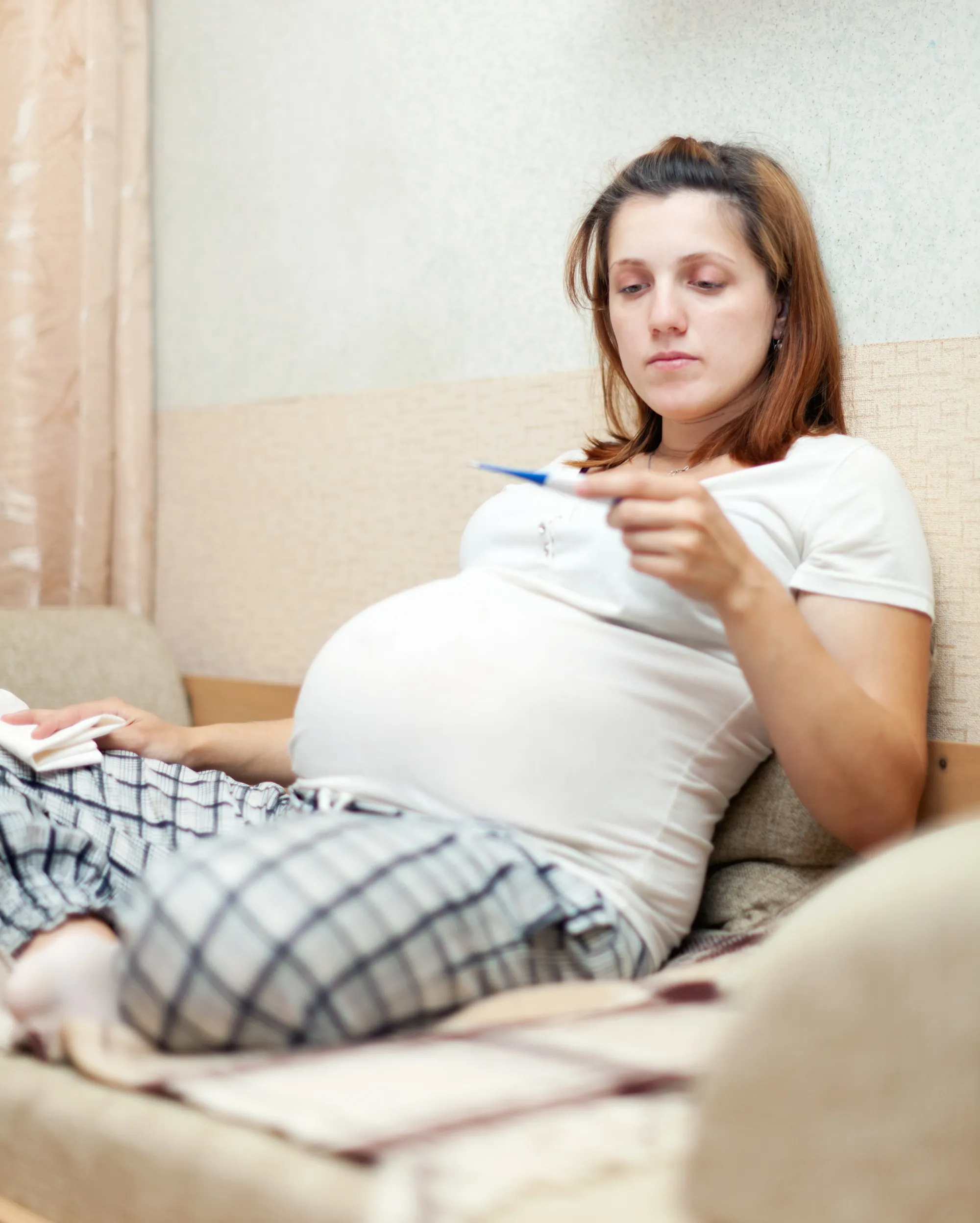 pregnant woman holding thermometer