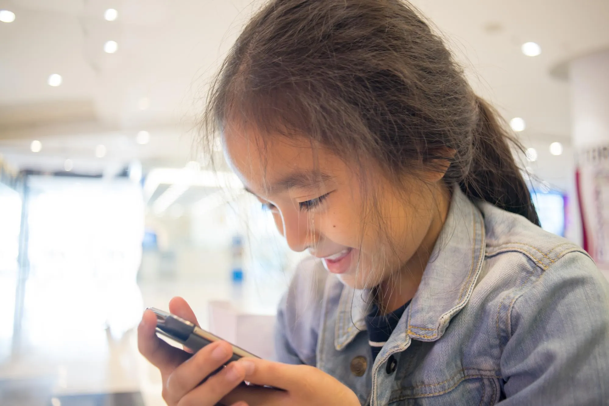 Smiling girl using mobile phone