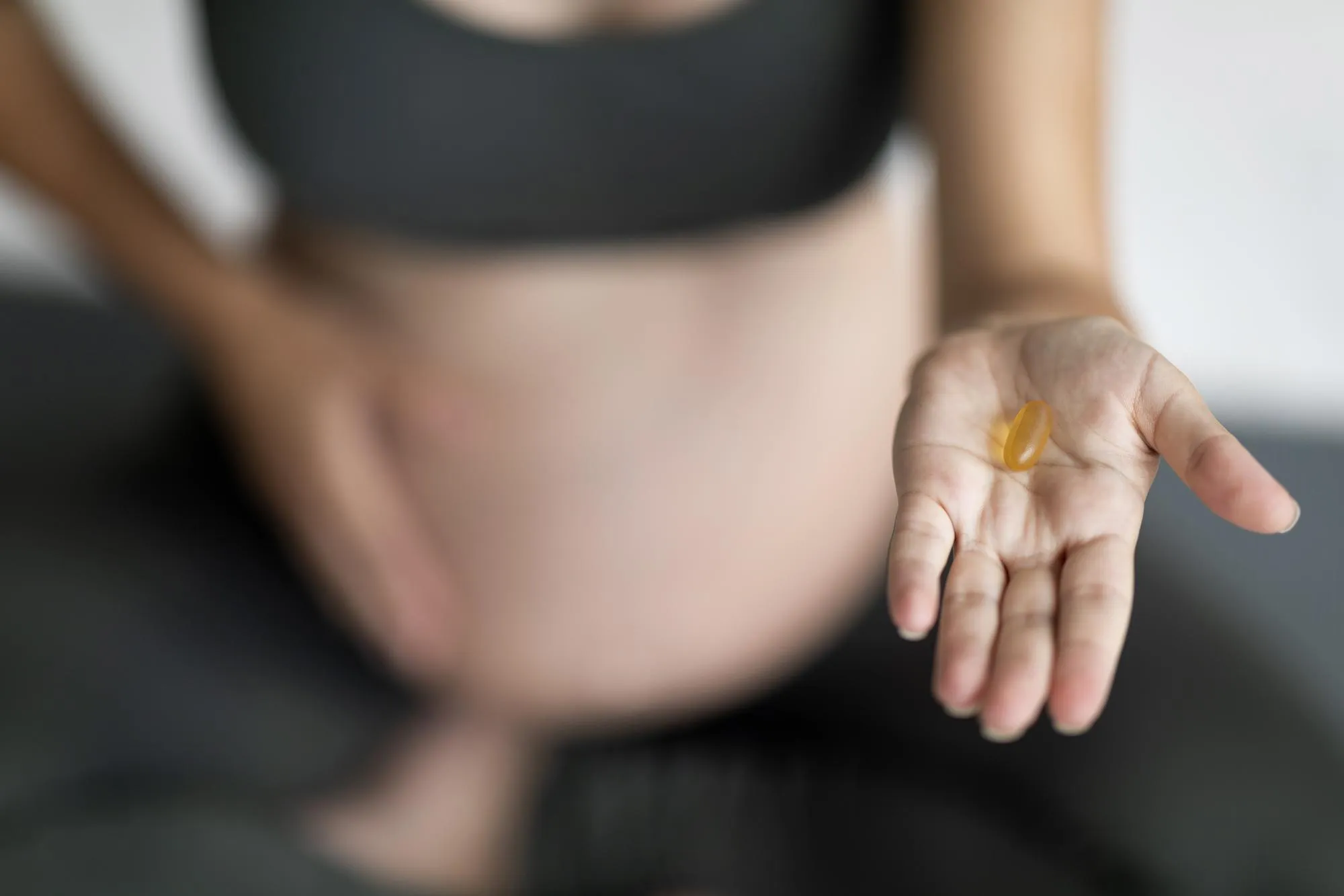 Unrecognizable Pregnant Woman Holding Vitamin Pill Capsule On Palm