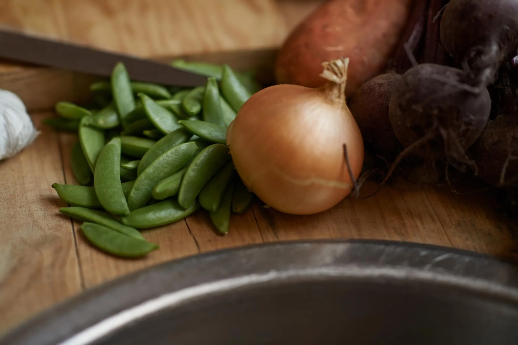 Vegetables onion and wooden board for cooking lunch dish and nutrition for diet at home Wellness health and organic food with meal vegetarian and green ingredients for vegan salad in a kitchen