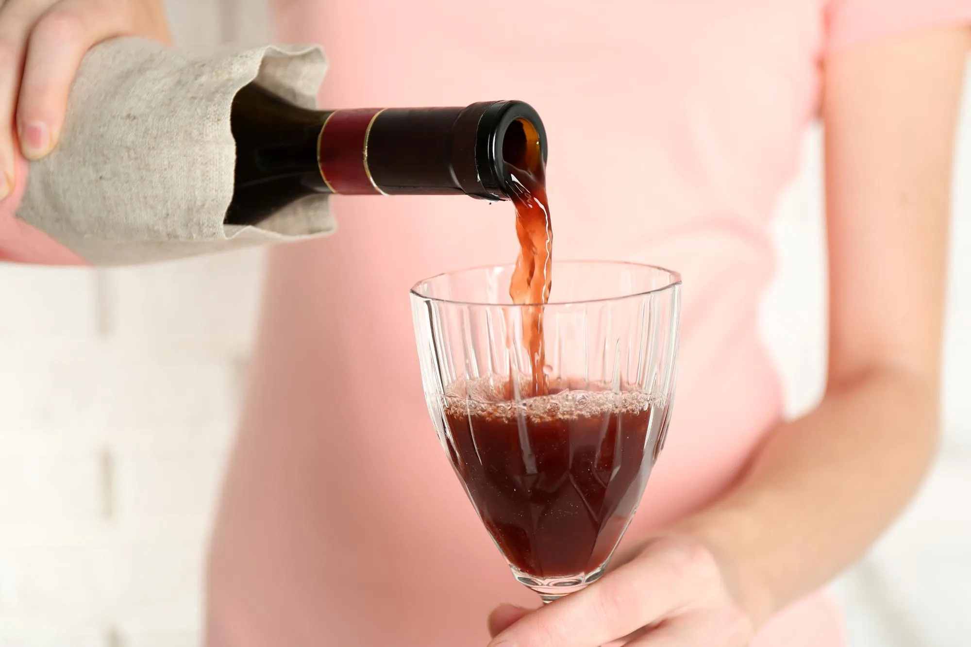 Woman pouring wine into glass close up