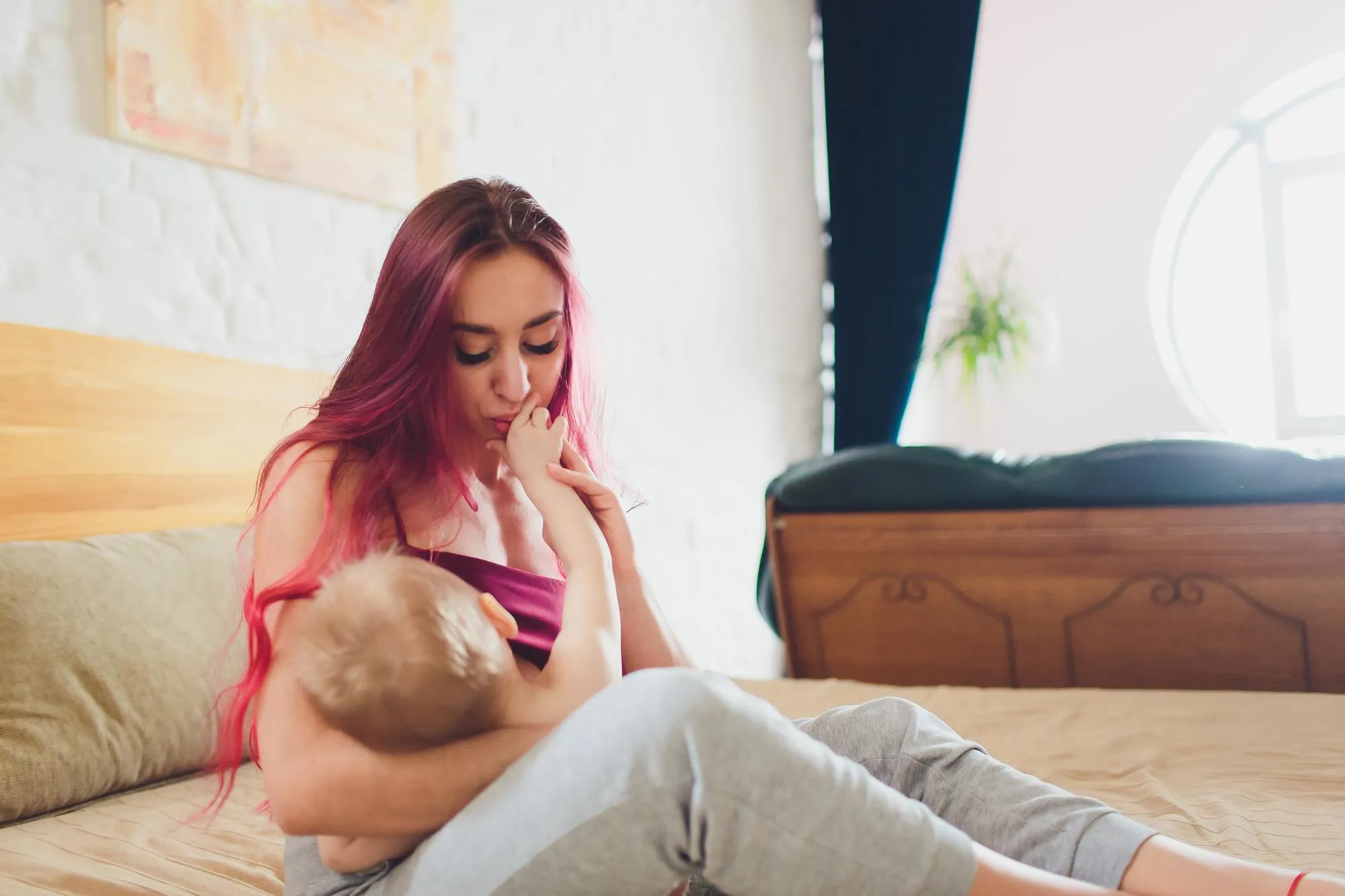 Young mother breastfeeding her newborn baby boy at home
