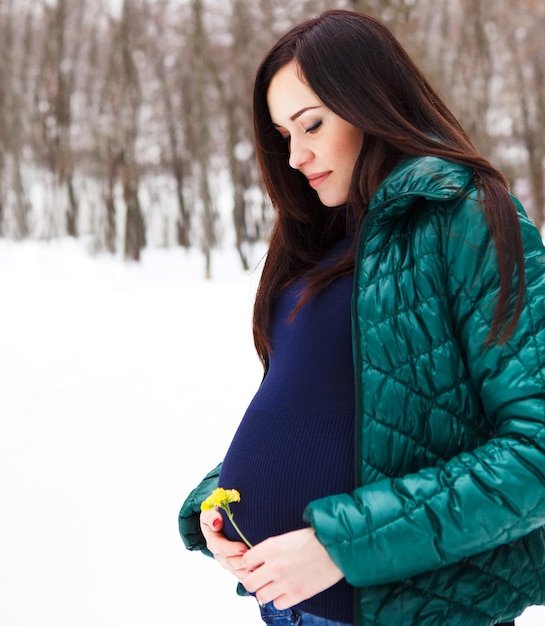Young woman looking away while standing in snow
