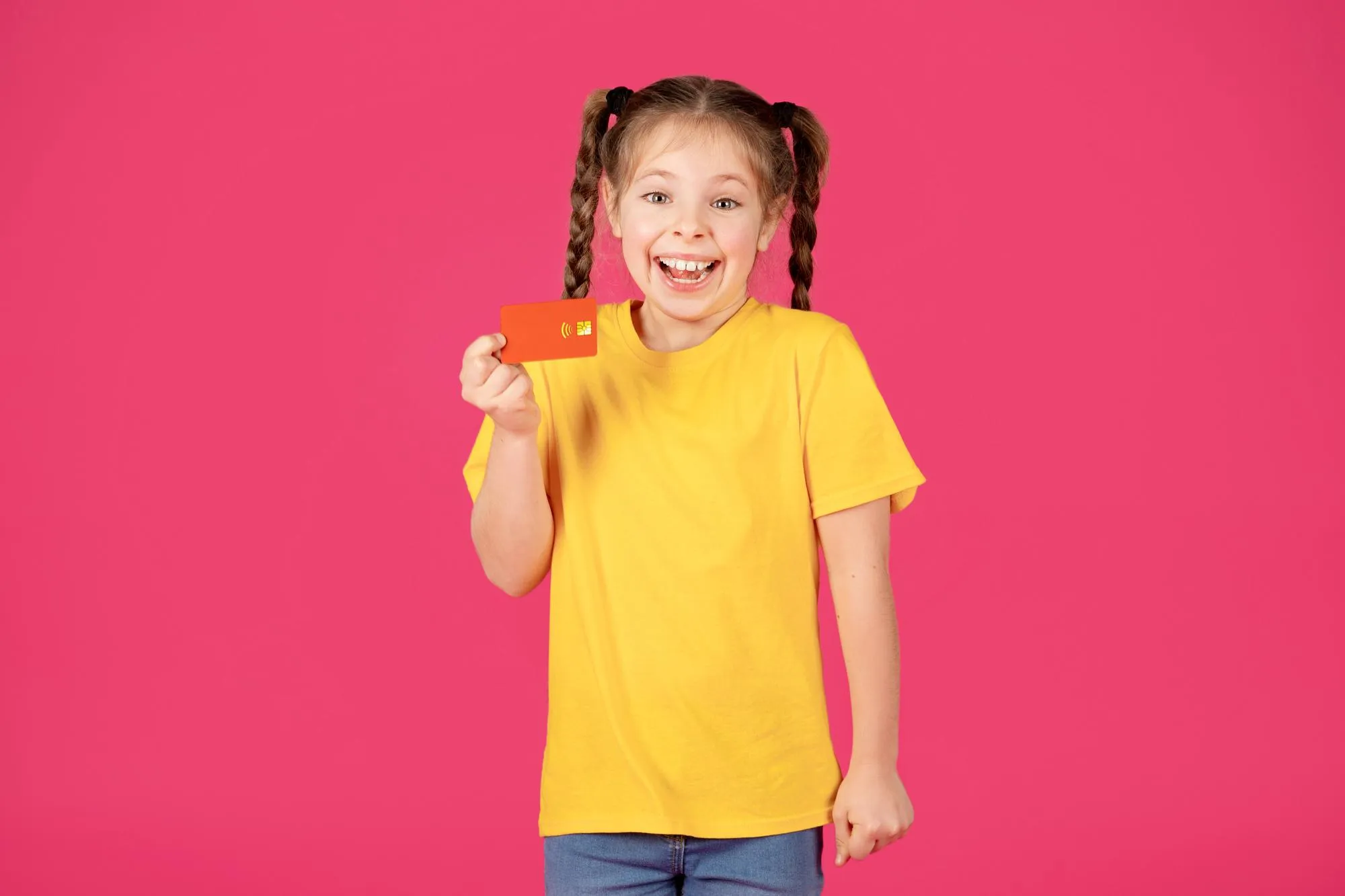 Cheerful Cute Little Girl Holding Credit Card And Looking At Camera