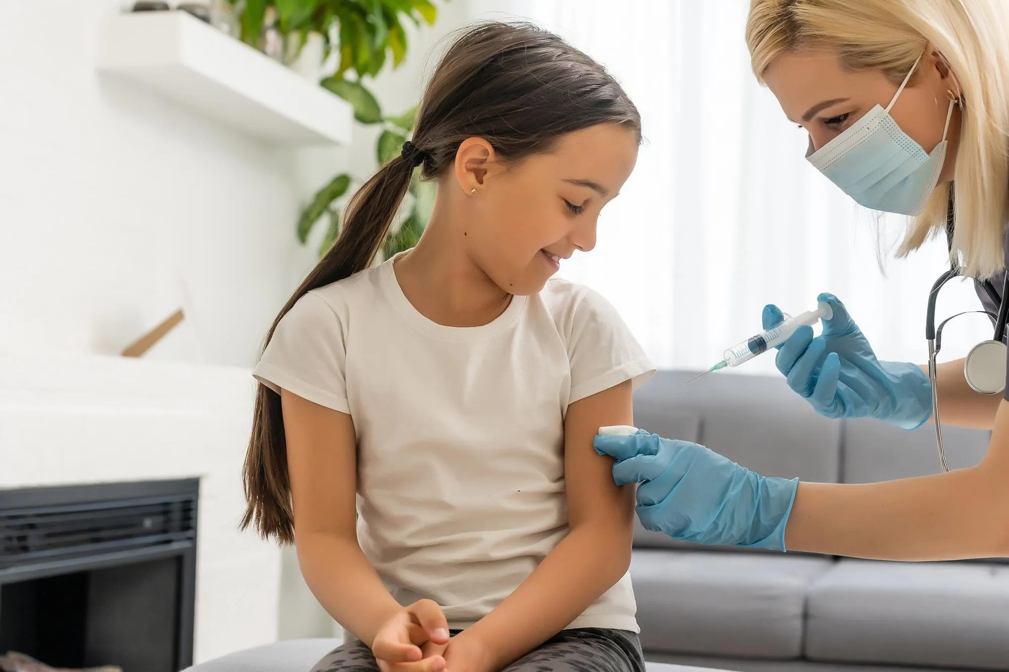 nurse giving vaccination injection to little girl patient.