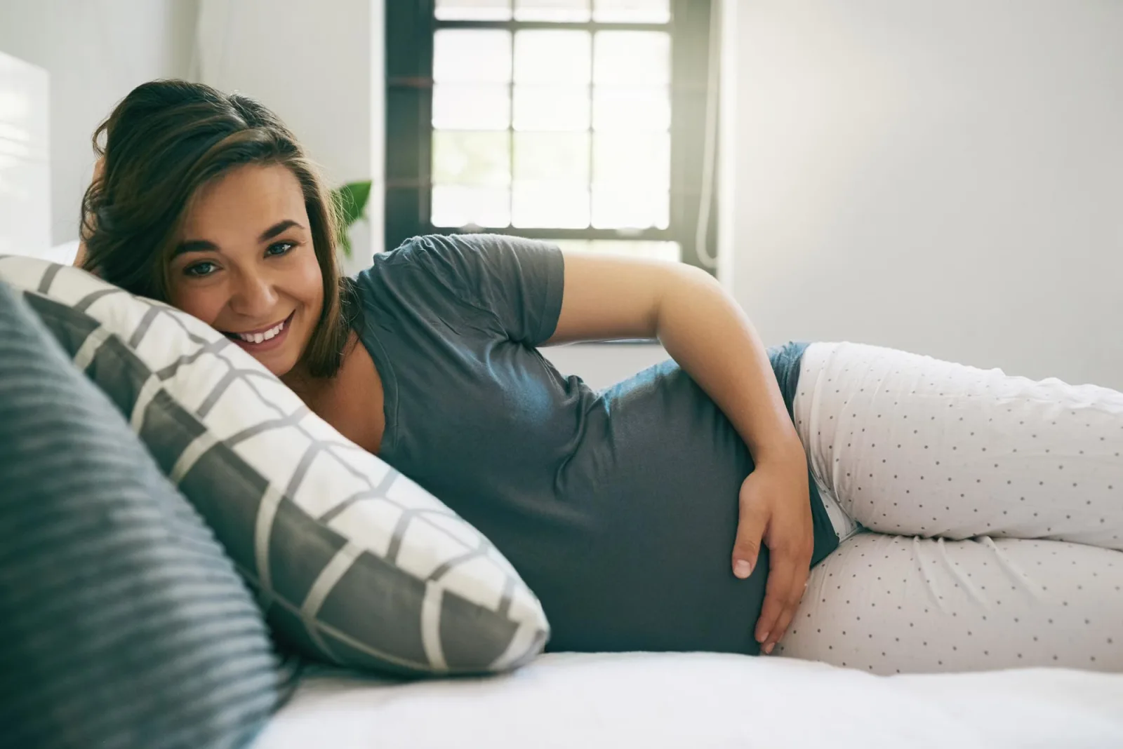 Portrait smile and pregnant woman touch stomach in home for relax maternity or expecting baby Pregnancy future and happy mother feeling abdomen and healthy belly for prenatal care in bedroom