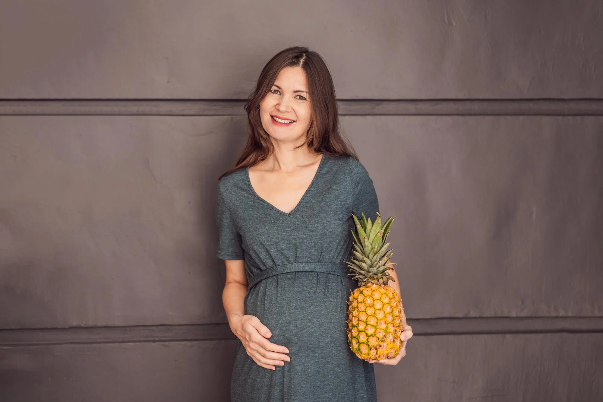 A pregnant womans belly beautifully showcasing the size of her baby likened to a pineapple Explore the potential benefits and harms of pineapple during pregnancy and childbirth