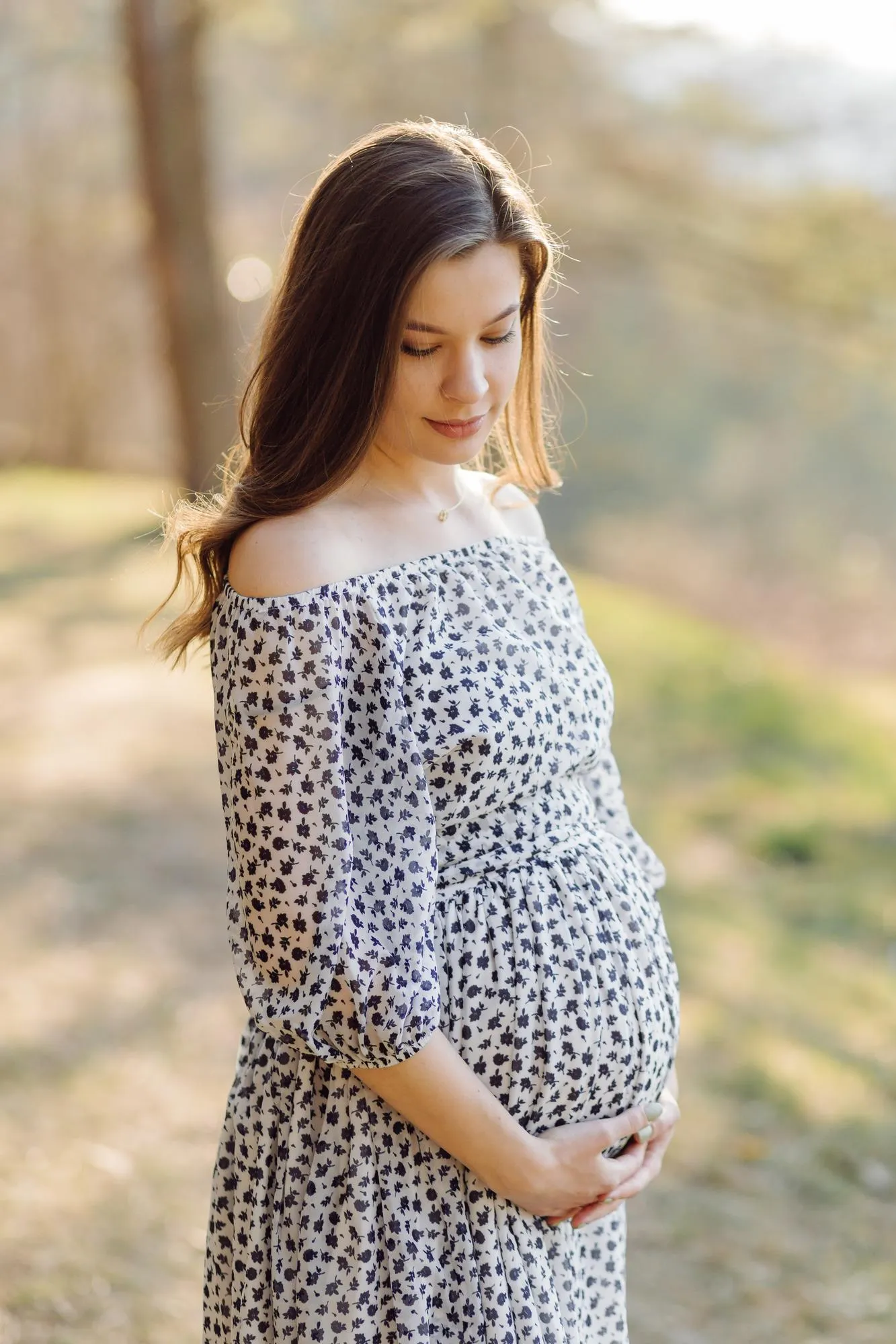 Young pregnant woman relaxing in park outdoors