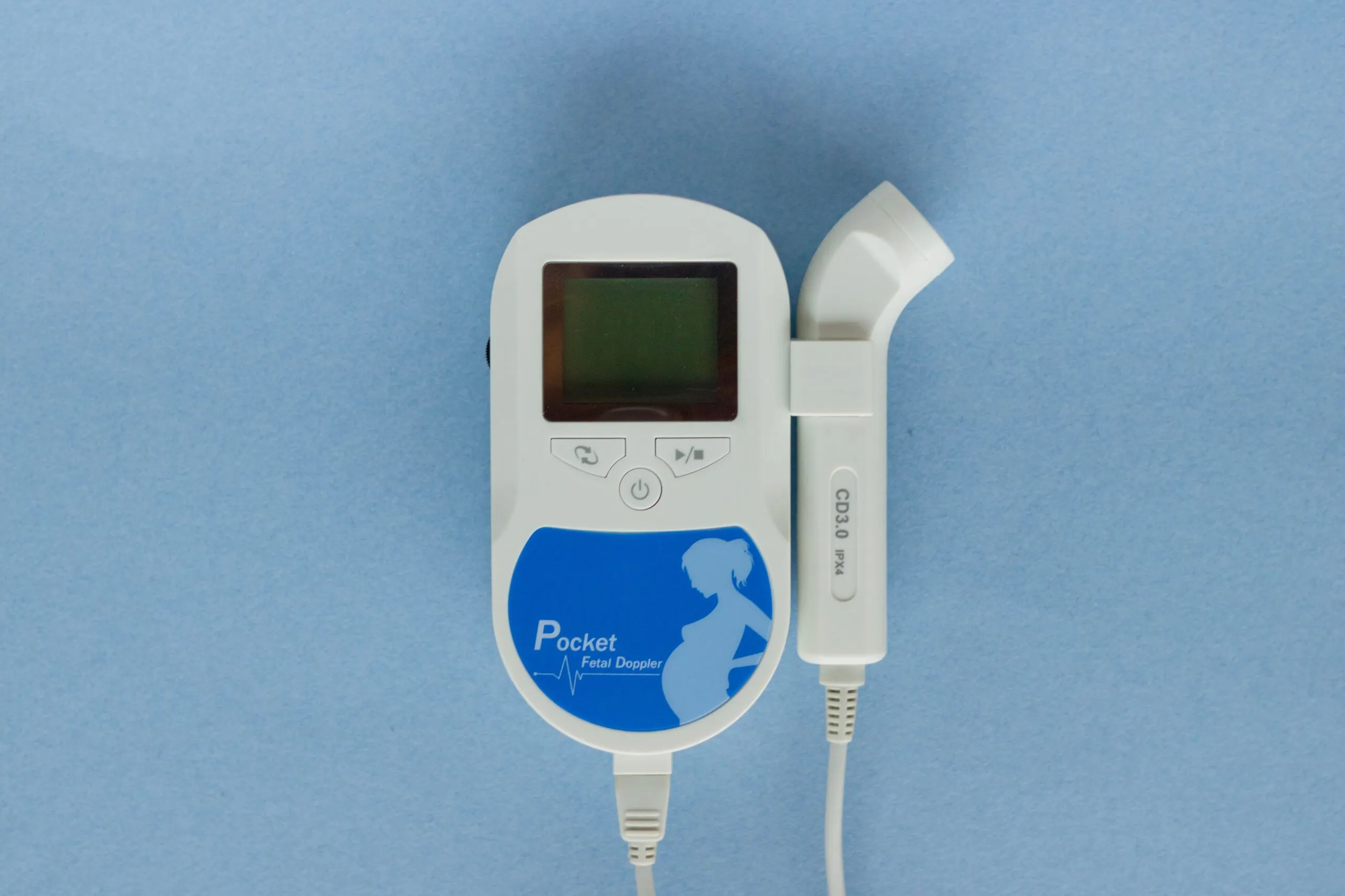 High-angle view of a pocket fetal doppler device on a blue background.