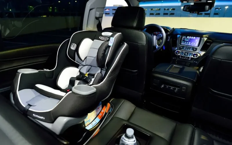 Interior of a car featuring a child safety seat and illuminated dashboard, captured at night.
