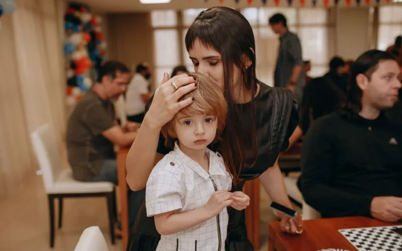 Mother comforting her child during an indoor family gathering. Warm and candid moment captured.
