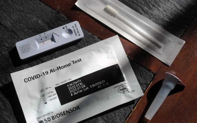 Close-up of a COVID-19 at-home test kit with packaging and test components displayed.