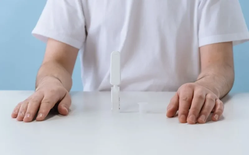 A person conducting an HIV test using an OraQuick kit, emphasizing home health diagnostics.